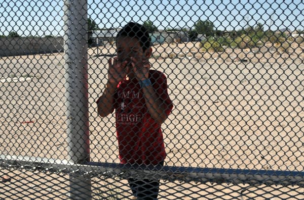 Nine-year-old Luis standing on the Mexican side of the border at Anapra, and talking through the fence with me and a friend. (Photo by Heath Haussamen)